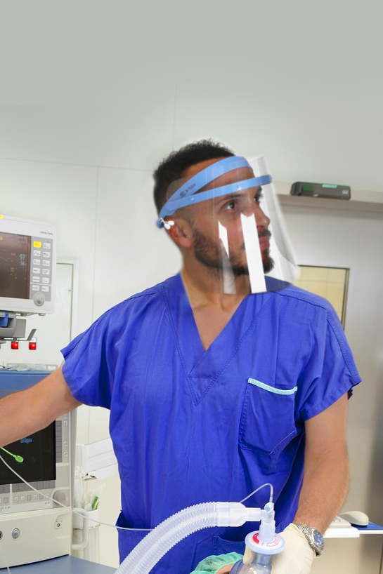 medico chirurgo anestetizza una paziente indossando una visiera sanitaria trasparente