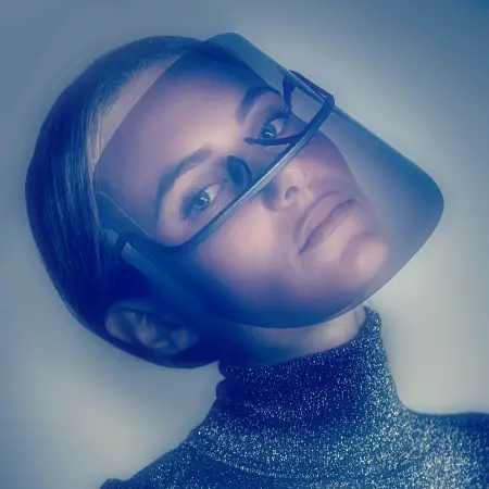 Una donna con la testa inclinata indossa uno scudo facciale